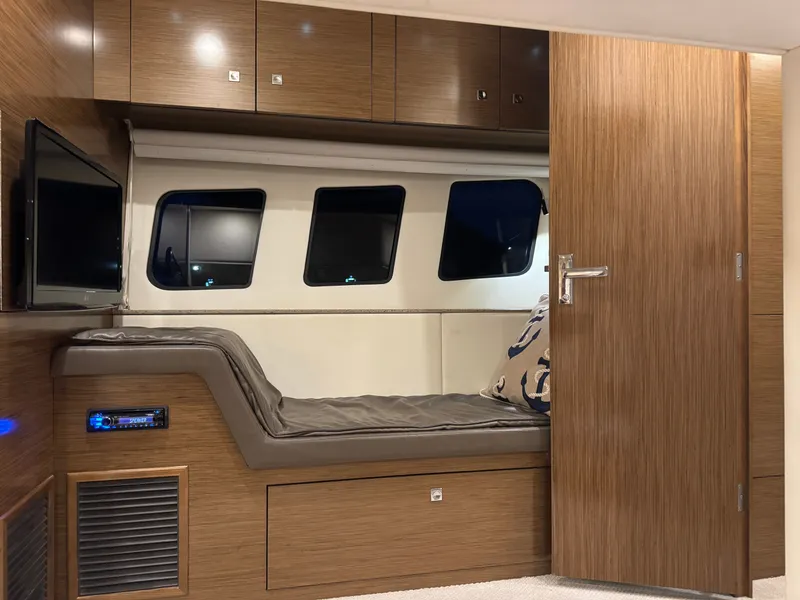 Slide: The Image of The cabin of a 2013 Cruisers Yachts 45 Cantius with a cozy bed and a TV. - 49