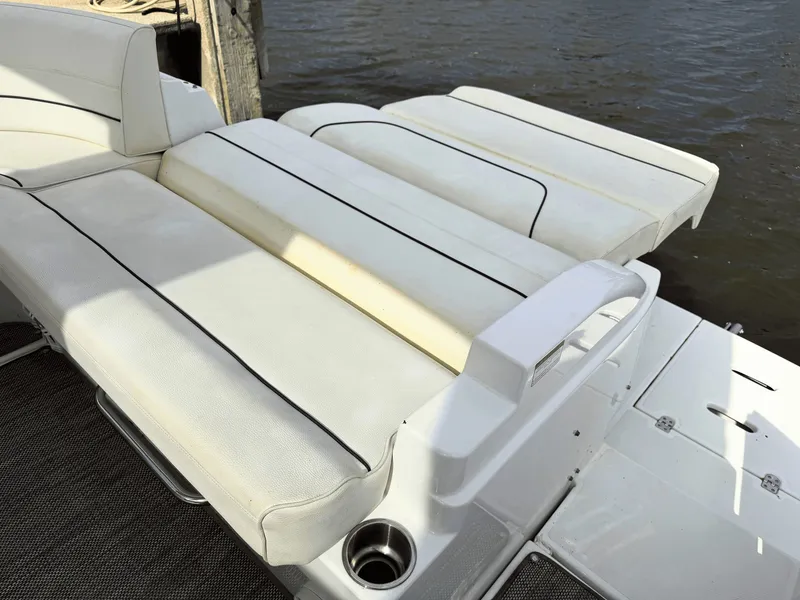 Slide: The Image of The image shows the white cushioned deck of a 2018 Cruisers Yachts 35 Express by the water. - 7