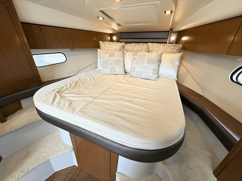 Slide: The Image of The cabin of the 2018 Cruisers Yachts 35 Express features a large, cozy bed with pillows. - 18
