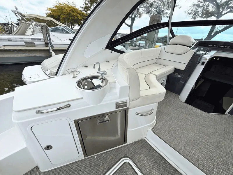 Slide: The Image of The image shows the cockpit of a 2018 Cruisers Yachts 35 Express with a sleek seating area and small sink. - 9