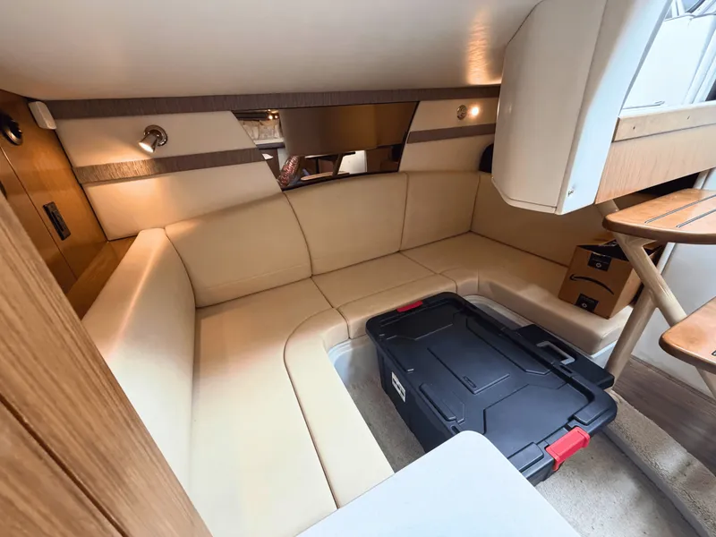 Slide: The Image of Interior of a 2018 Cruisers Yachts 35 Express with beige upholstered seating and storage. - 20