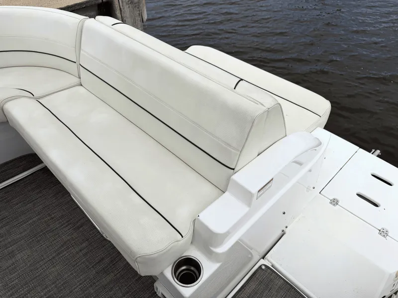 Slide: The Image of The image shows a white bench seat on a boat docked by the water. - 6