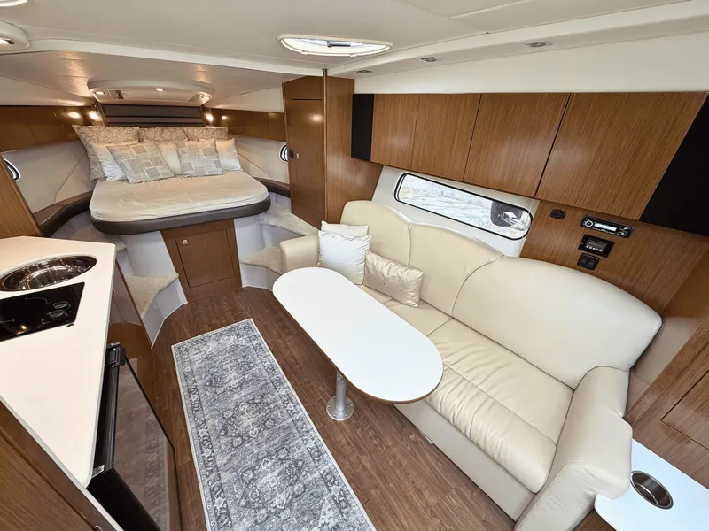 Slide: The Image of Interior of the 2018 Cruisers Yachts 35 Express with sofa, table, and bed. - 14