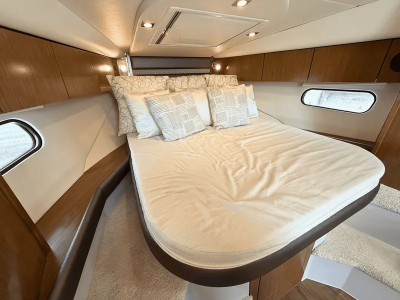 Slide: The Image of The cabin of the 2018 Cruisers Yachts 35 Express features a cozy bed with pillows. - 19