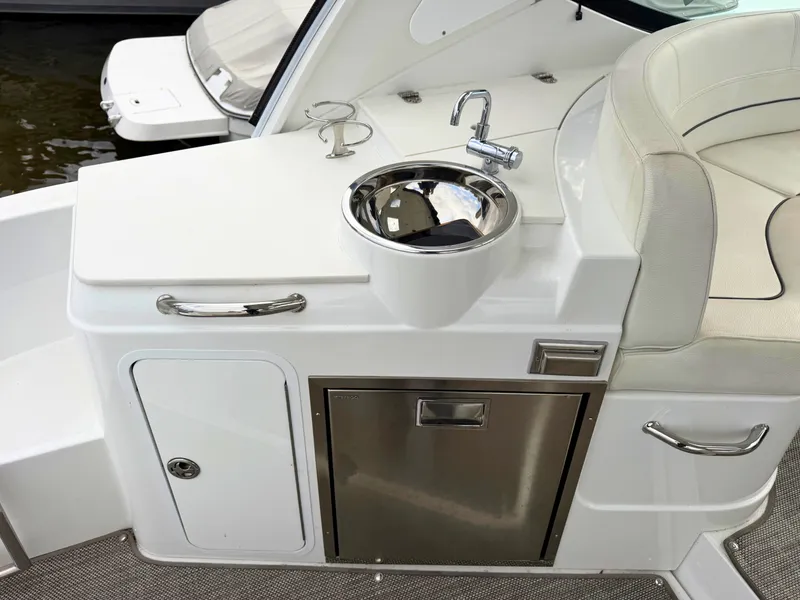 Slide: The Image of The 2018 Cruisers Yachts 35 Express features a compact outdoor kitchen with a sink and storage. - 10