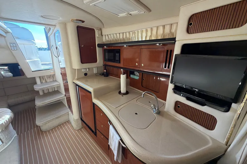 Slide: The Image of Luxurious interior of 2002 Sea Ray 340 Sundancer yacht with kitchenette and TV. - 29