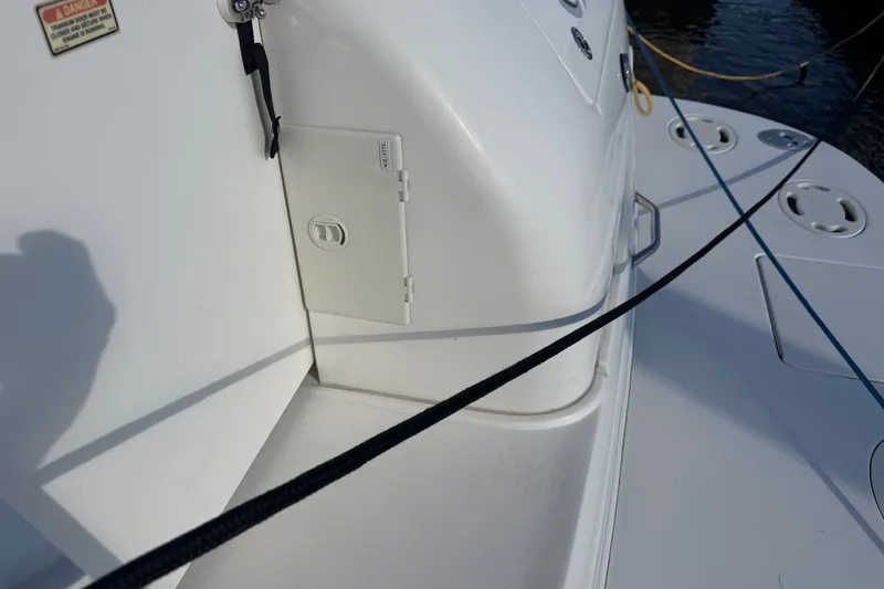 Slide: The Image of Close-up of 2002 Sea Ray 340 Sundancer deck with storage compartment and safety warning. - 10