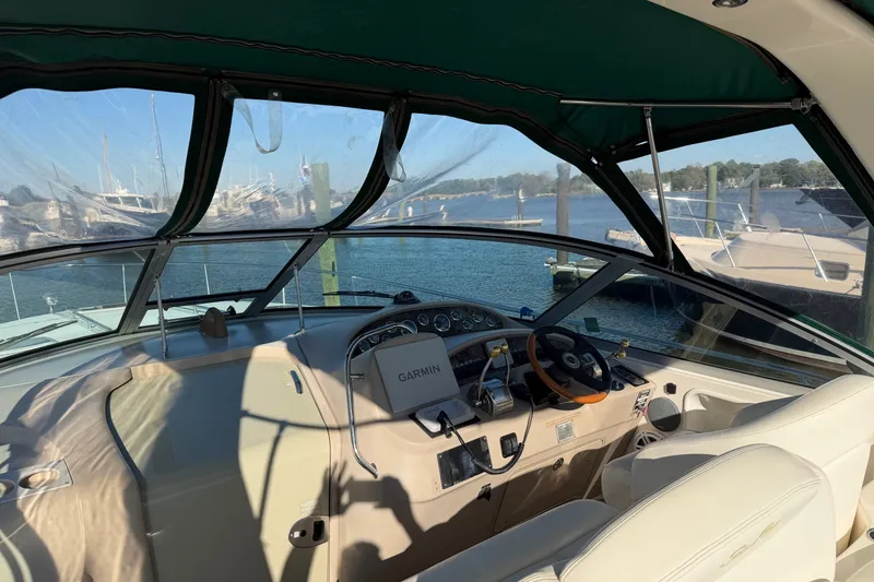 Slide: The Image of 2002 Sea Ray 340 Sundancer cockpit with Garmin navigation, docked by the water. - 13