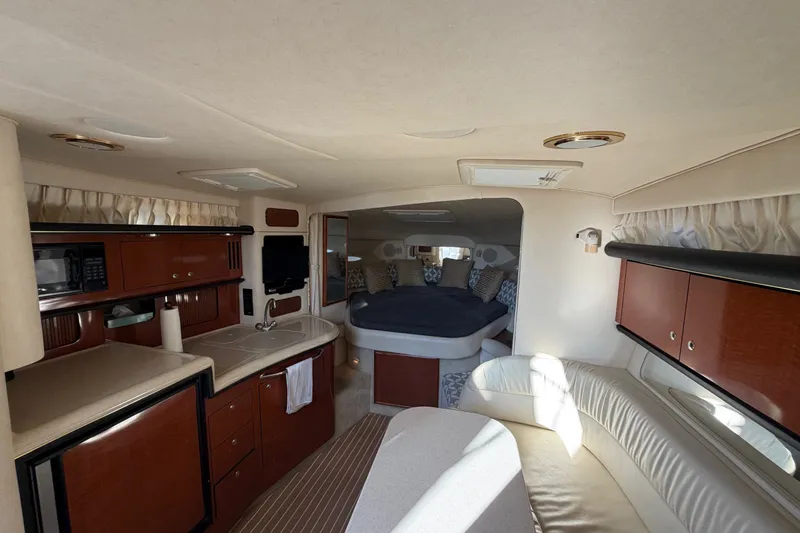 Slide: The Image of Interior of 2002 Sea Ray 340 Sundancer yacht with kitchen, seating, and sleeping area. - 32