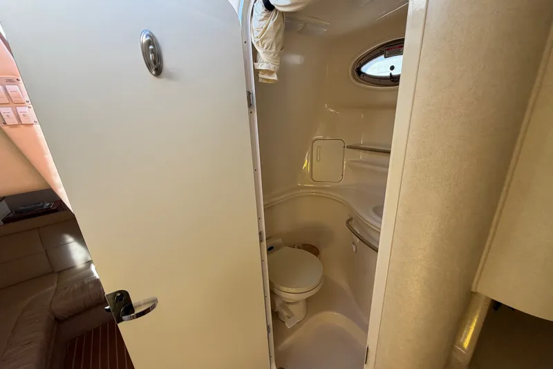 Slide: The Image of 2002 Sea Ray 340 Sundancer bathroom interior with compact design and porthole window. - 35