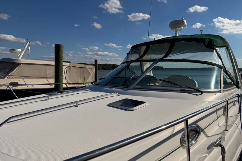 Slide: The Image of 2002 Sea Ray 340 Sundancer yacht docked under a clear blue sky. - 7