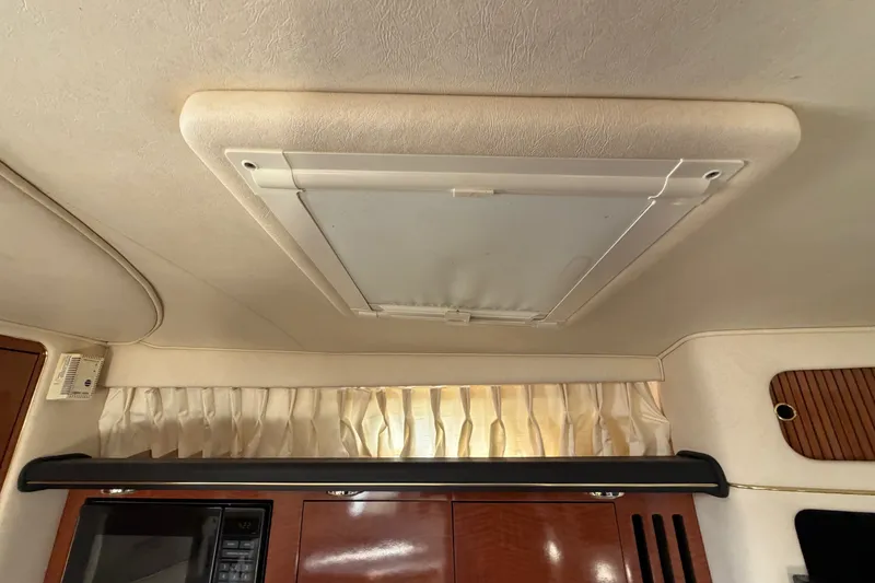 Slide: The Image of Ceiling hatch inside 2002 Sea Ray 340 Sundancer boat cabin, with wood paneling and curtains. - 46