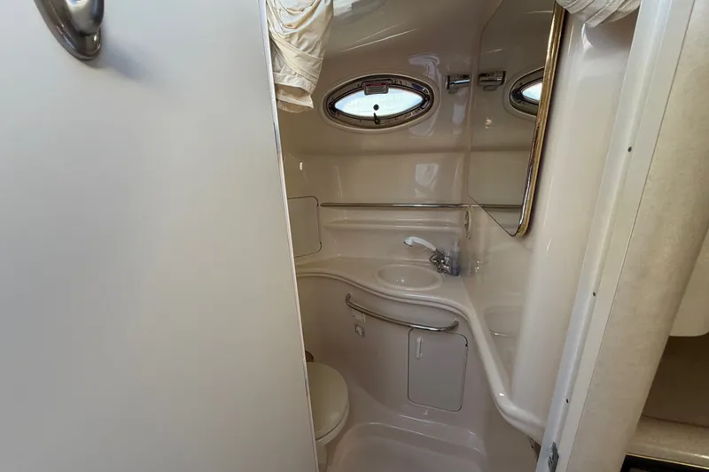 Slide: The Image of 2002 Sea Ray 340 Sundancer bathroom interior with sink and porthole windows. - 34