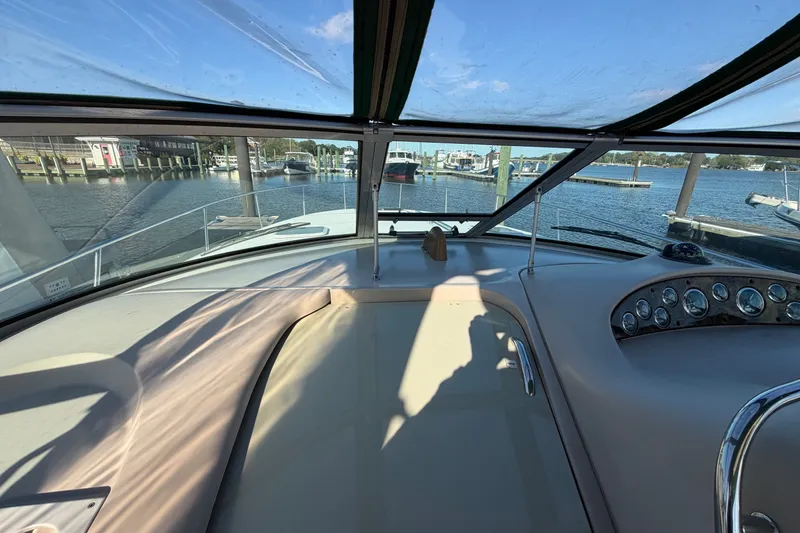 Slide: The Image of Cockpit view of 2002 Sea Ray 340 Sundancer at marina, showcasing dashboard and waterfront. - 18