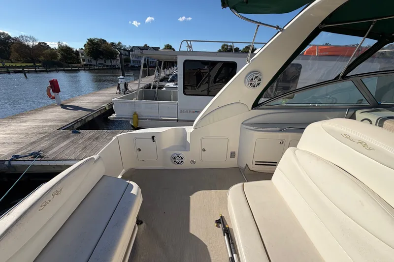 Slide: The Image of 2002 Sea Ray 340 Sundancer yacht interior at dock, featuring spacious seating and elegant design. - 22