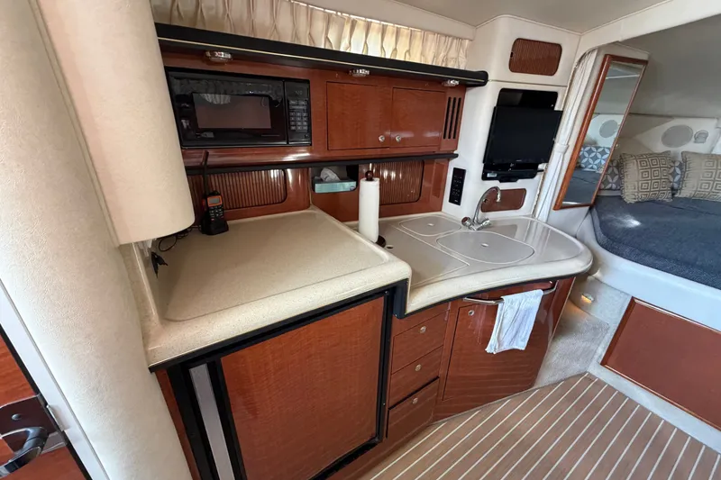 Slide: The Image of Interior of 2002 Sea Ray 340 Sundancer yacht with kitchenette and cozy sleeping area. - 40