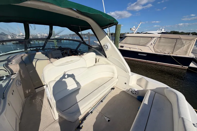 Slide: The Image of 2002 Sea Ray 340 Sundancer boat interior with seating, docked at marina under clear sky. - 21