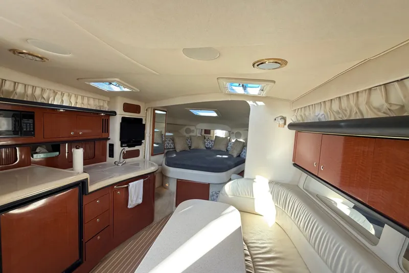 Slide: The Image of Interior of 2002 Sea Ray 340 Sundancer yacht with kitchen, seating, and sleeping area. - 44