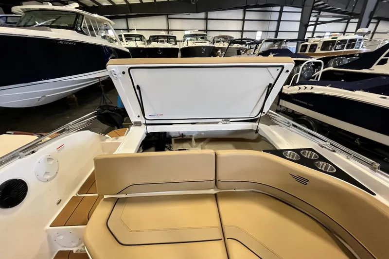 Slide: The Image of 2025 Bayliner V20i boat interior with open storage compartment and beige seating. - 15