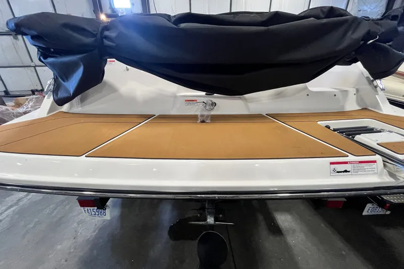 Slide: The Image of 2025 Bayliner V20i boat with covered seating and teak deck in a garage. - 18