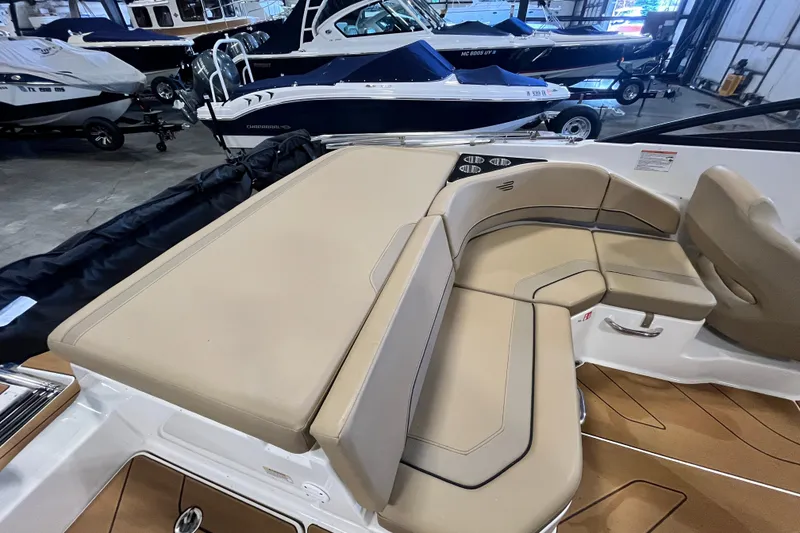 Slide: The Image of 2025 Bayliner V20i boat interior with beige seating in a showroom. - 14