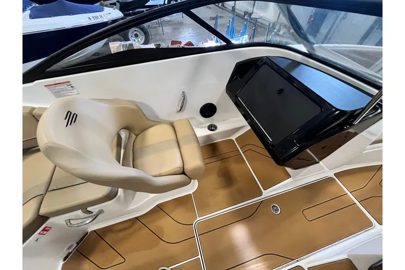 Slide: The Image of Interior of 2025 Bayliner V20i boat with beige seating and brown flooring. - 11
