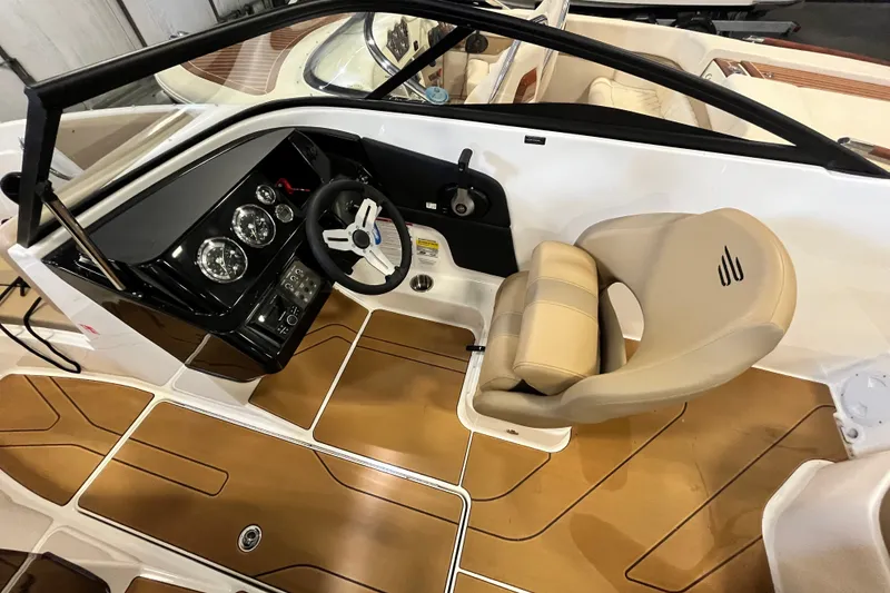 Slide: The Image of 2025 Bayliner V20i boat interior with steering wheel and beige seating. - 9