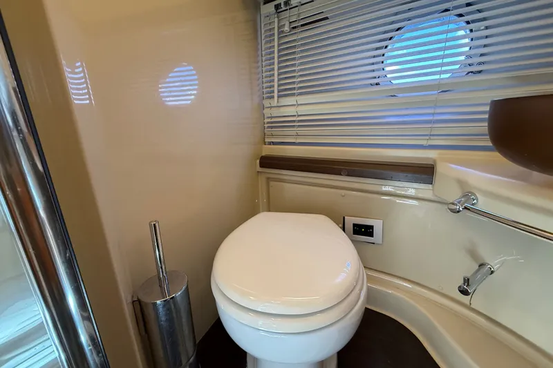 Slide: The Image of Luxury yacht bathroom interior on a 2015 Azimut 54, featuring modern fixtures and porthole window. - 97