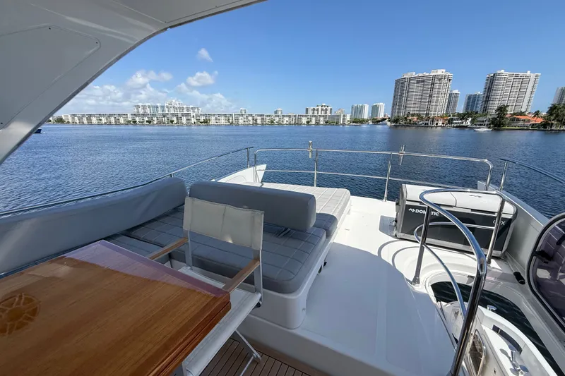 Slide: The Image of 2015 Azimut 54 yacht deck with seating, table, and scenic waterfront view. - 44