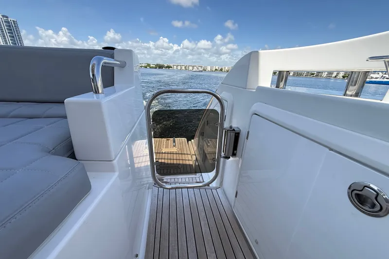 Slide: The Image of Azimut 54 yacht deck view with open gate, overlooking water and cityscape, 2015 model. - 62