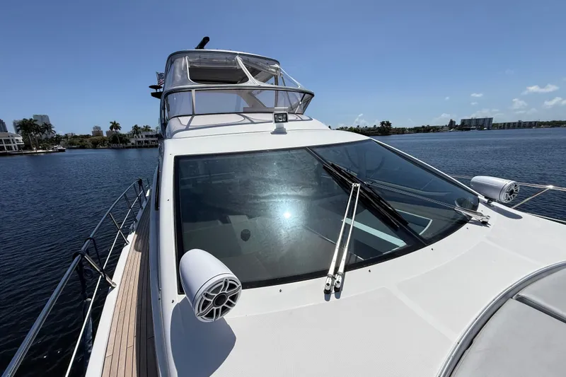 Slide: The Image of 2015 Azimut 54 yacht on calm water, showcasing sleek design and spacious deck. - 14