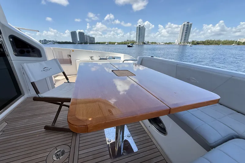 Slide: The Image of Luxury Azimut 54 yacht deck with wooden table, chairs, and waterfront view, 2015 model. - 64