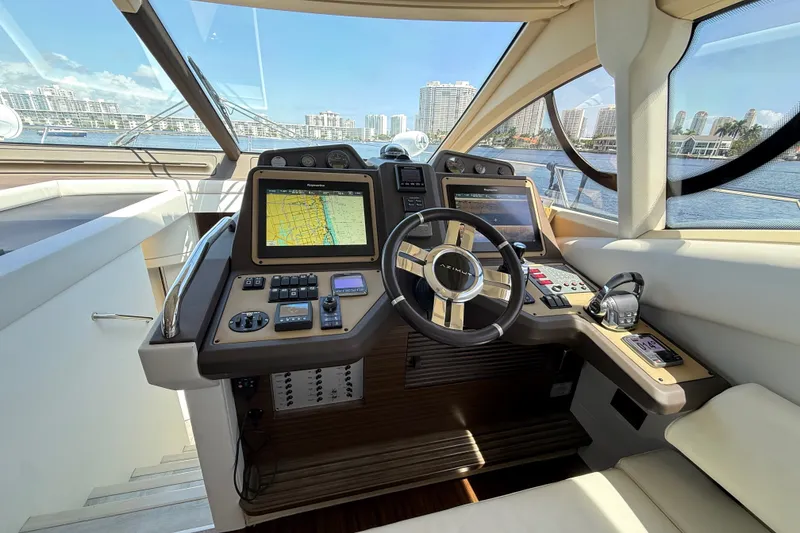 Slide: The Image of Cockpit of 2015 Azimut 54 yacht with navigation screens and steering wheel, overlooking waterfront cityscape. - 72