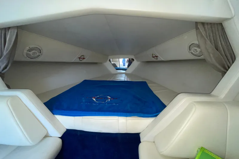 Slide: The Image of Interior cabin of 2002 Fountain 35 Lightning boat with blue bedding and white seating. - 27