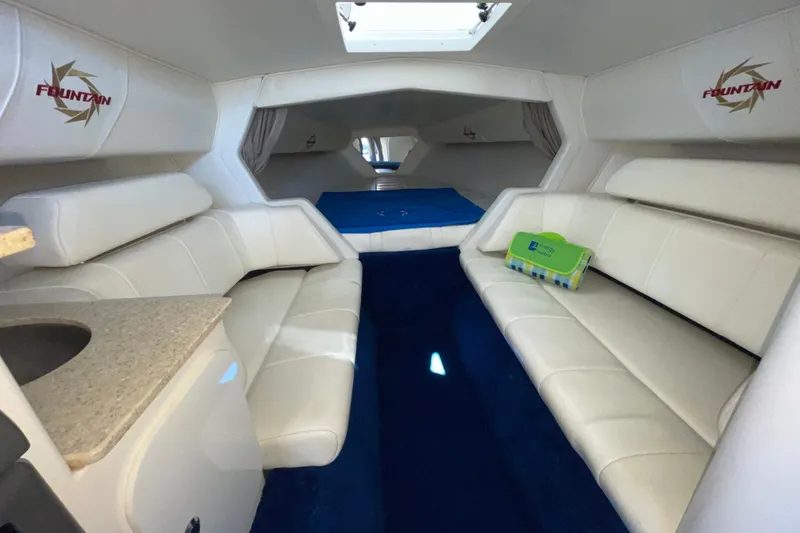 Slide: The Image of Interior of a 2002 Fountain 35 Lightning boat with white seating and blue carpet. - 26