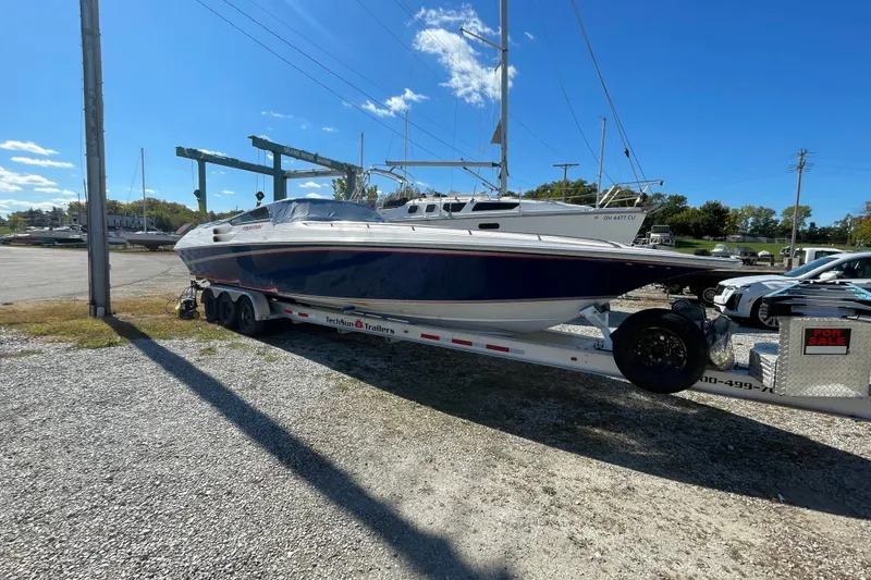 Slide: The Image of 2002 Fountain 35 Lightning boat on trailer, parked outdoors under clear blue sky. - 4