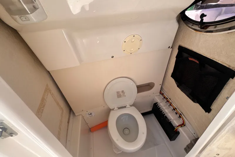 Slide: The Image of Interior view of a 2017 Robalo R242 Center Console boat's compact marine toilet. - 17