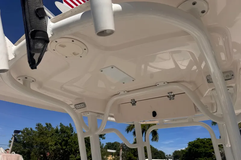 Slide: The Image of 2017 Robalo R242 Center Console boat's T-top structure under clear blue sky. - 22