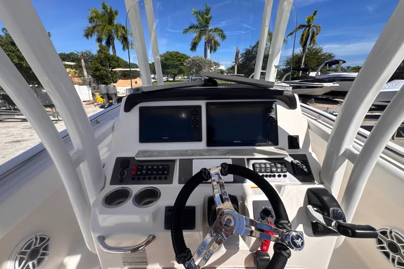 Slide: The Image of 2017 Robalo R242 Center Console boat dashboard with steering wheel and navigation screens. - 13