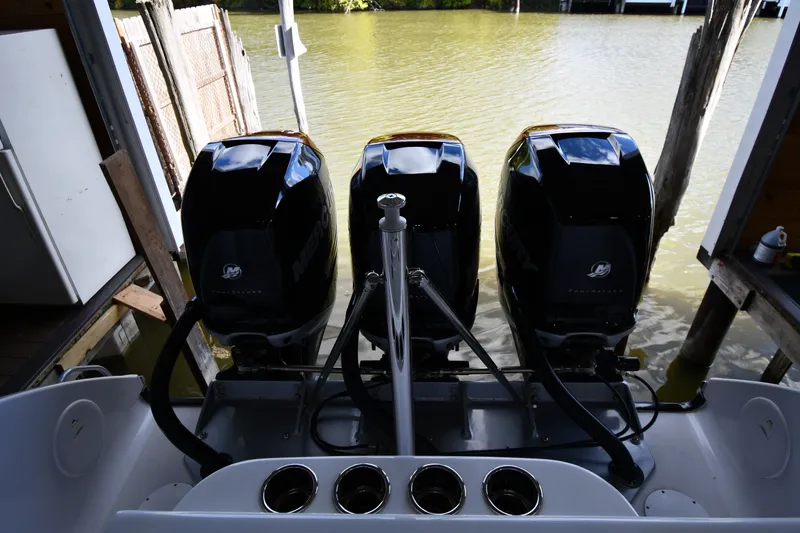 Slide: The Image of Triple Mercury outboard engines on a 2009 Donzi 38 ZFX Open boat docked by water. - 16