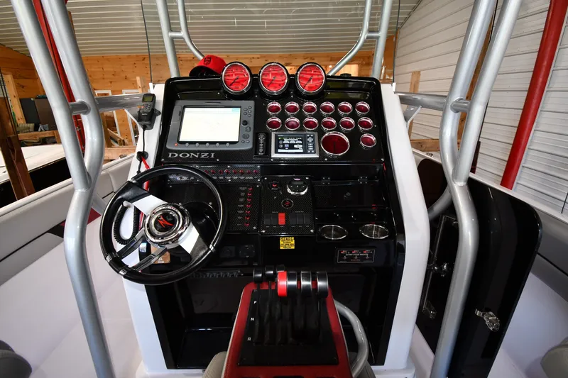 Slide: The Image of 2009 Donzi 38 ZFX Open boat dashboard with steering wheel and navigation controls. - 53