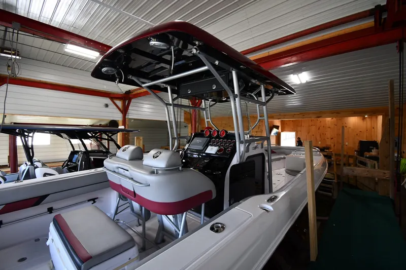 Slide: The Image of 2009 Donzi 38 ZFX Open boat in indoor storage, showcasing helm and seating area. - 7