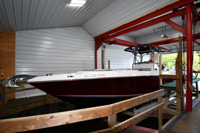 Slide: The Image of 2009 Donzi 38 ZFX Open boat in a covered dock, showcasing sleek design and vibrant color. - 3
