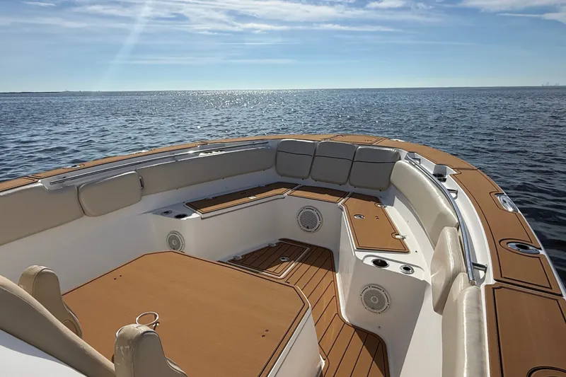 Slide: The Image of 2017 Sea Fox 328 Commander boat interior with cushioned seating, on a calm ocean. - 13