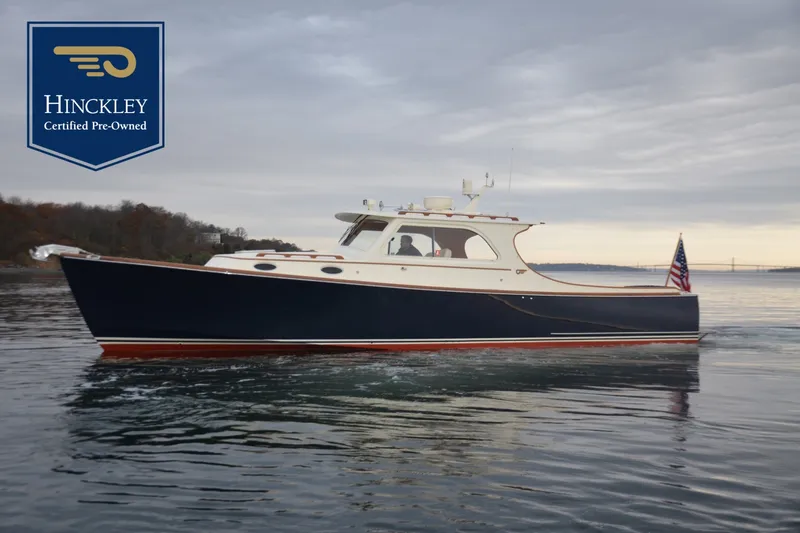The Image of 2002 Hinckley Picnic Boat 36 EP on calm water with an American flag. - 0