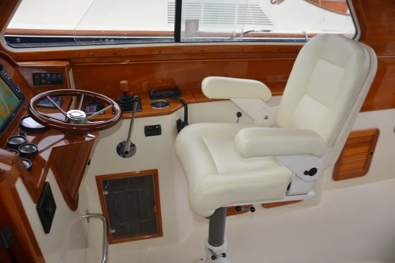 Slide: The Image of Helm station of 2002 Hinckley Picnic Boat 36 EP with white captain's chair and wooden dashboard. - 15