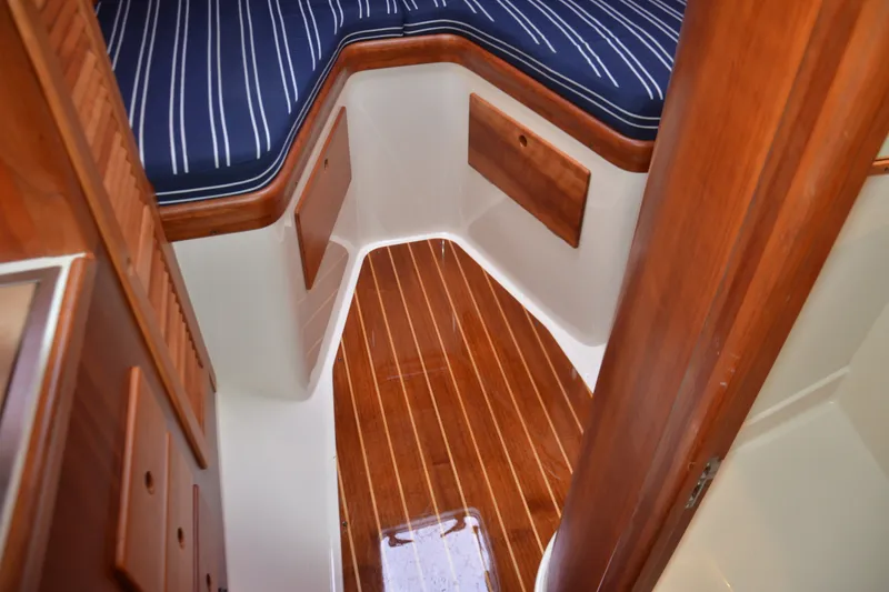 Slide: The Image of 2002 Hinckley Picnic Boat 36 EP interior with striped cushions and polished wood flooring. - 17