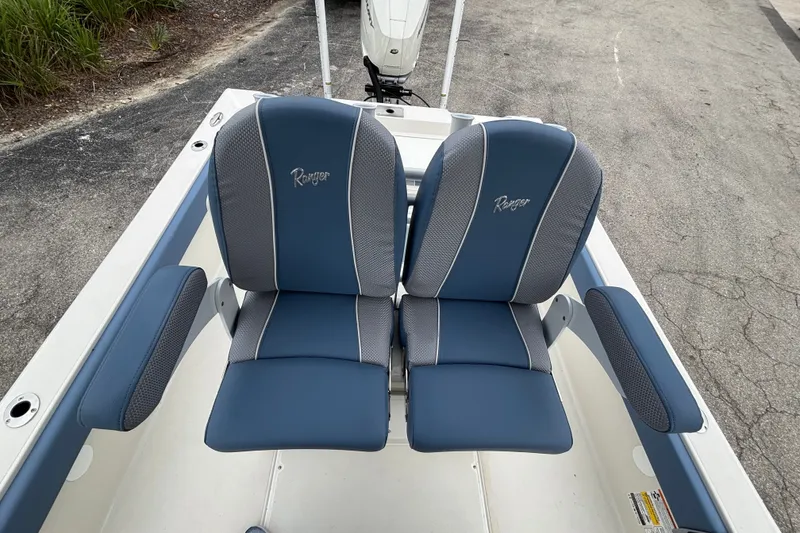 Slide: The Image of 2027 Ranger 2660 Bay boat seats, blue and gray upholstery, on a paved surface. - 30