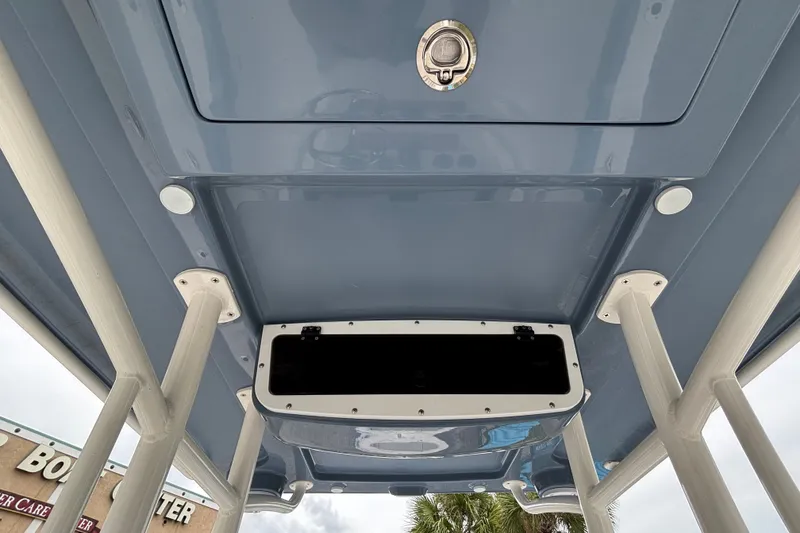 Slide: The Image of 2027 Ranger 2660 Bay boat's T-top interior with storage compartment and support poles. - 19