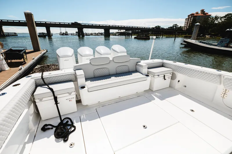 Slide: The Image of 2026 HCB 48 Campeón boat interior with seating and storage, docked by a scenic waterfront. - 42